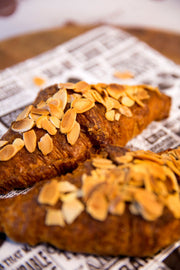 Croissants with almonds on a newspaper surface